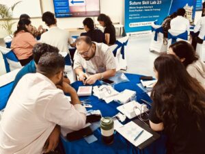 Group of professionals at a workshop table, leaning in to examine papers and gadgets on a blue cloth.