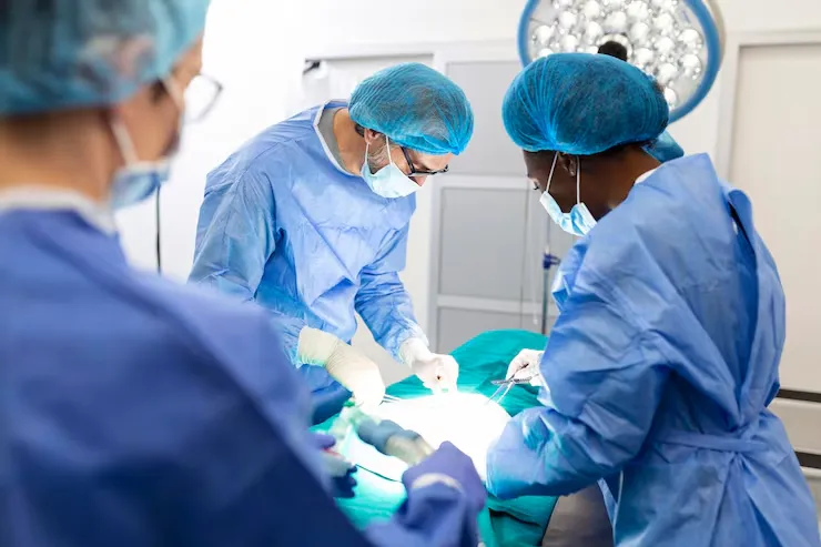 image11 - gisurgeryexpert.com/ Surgeons wearing masks and caps performing an operation under bright surgical lights.